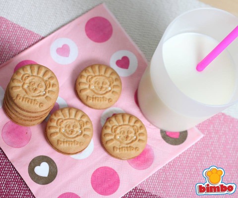 Galletas Bimbo con un vaso de leche encima de una servilleta rosada