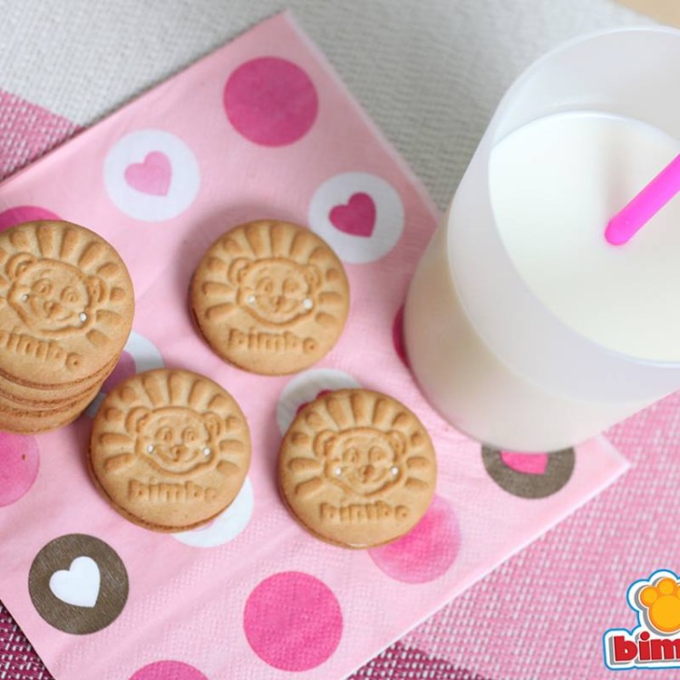 Galletas Bimbo con un vaso de leche encima de una servilleta rosada